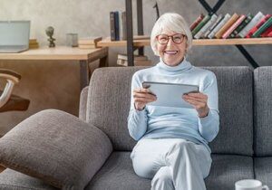 Summerville-senior-on-couch-with-ipad-300x210